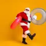 Full size profile side photo of white grey hair bearded santa claus rest x-mas christmas time go hold rubber circle wear sunglass headwear boots isolated bright shine color background